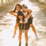 two-beautiful-cheerful-young-women-having-fun-enjoying-piggyback-ride-walking-sunny-avenue_360066-25728