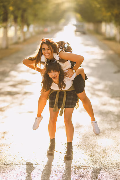 two-beautiful-cheerful-young-women-having-fun-enjoying-piggyback-ride-walking-sunny-avenue_360066-25728